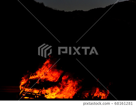 burning car on the road at night, a tragic 68161281