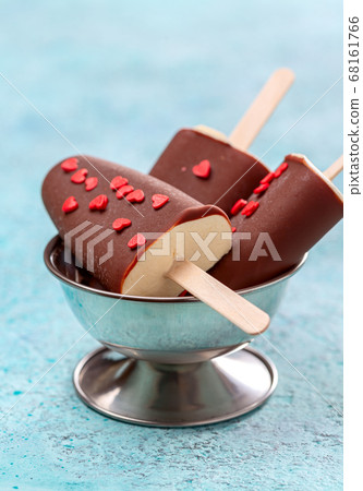 Artisanal ice cream in dark chocolate glaze. 68161766