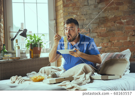 Lazy man living the whole life in his bed surrounded with messy Lazy man living the whole life in his bed surrounded with messy 68163557