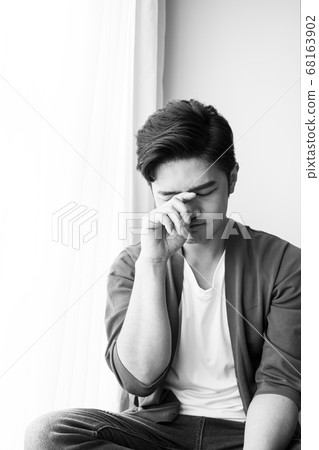 Young asian man rubbing his eyes 68163902