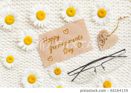 Happy Grandparents day background. Flowers on white knitted background Happy Grandparents day background. Flowers on white knitted background 68164139