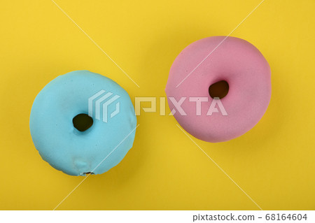 Two glazed donuts over yellow Two glazed donuts over yellow 68164604