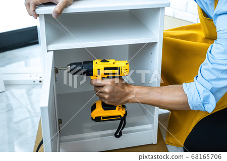Man doing renovation work at home drilling wood Man doing renovation work at home drilling wood 68165706