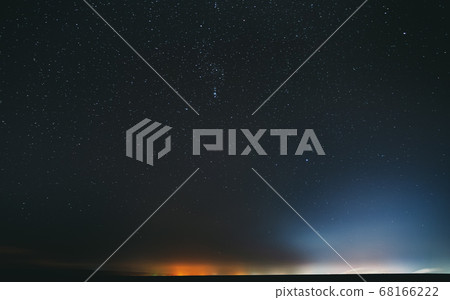 Night Starry Sky With Glowing Stars Above Countryside Landscape. Rural Field Meadow In Early Spring. Bright Glowing Stars Night Starry Sky With Glowing Stars Above Countryside Landscape. Rural Field Meadow In Early Spring. Bright Glowing Stars 68166222