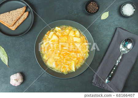 Chicken soup on black bowl on dark black stone Chicken soup on black bowl on dark black stone 68166407