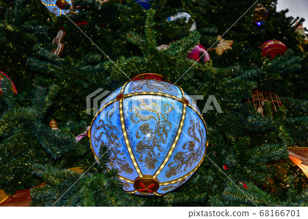 Christmas tree branch with snow and blue ornament. 68166701