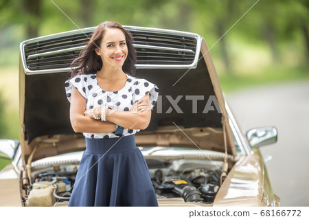 Confident woman stand in front of a car with open 68166772