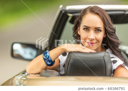 Smiling good looking girl sits behind the driving Smiling good looking girl sits behind the driving 68166791