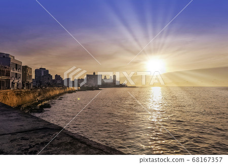Sunset over Malecon and Atlantic Ocean with residential building in background - Havana, Cuba 68167357