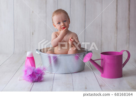 One year old baby girl takes a bath.  68168164