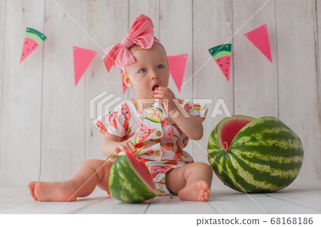 One year old baby girl eats watermelon. One year old baby girl eats watermelon. 68168186