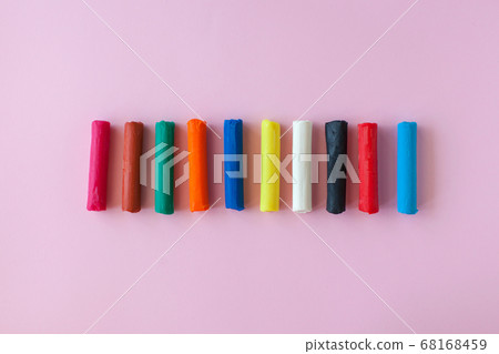 Multi-colored children's plasticine on a pink background. 68168459