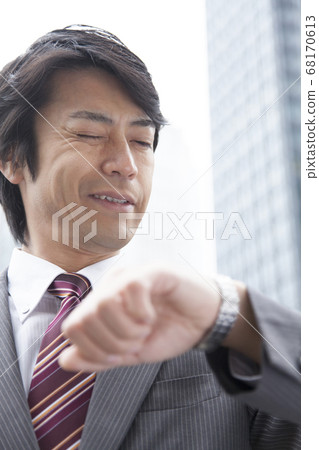 A businessman looking at a watch A businessman looking at a watch 68170613