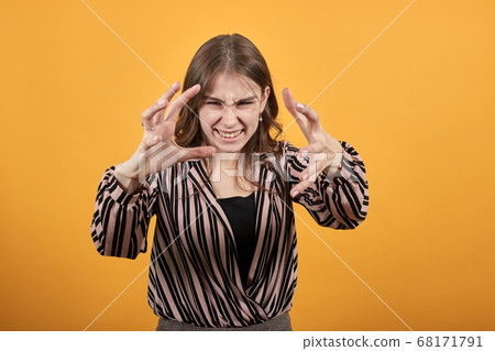 Angry, Irritated Girl Holds Her Hands Tensely In Front Of And Is Nervous Angry, Irritated Girl Holds Her Hands Tensely In Front Of And Is Nervous 68171791