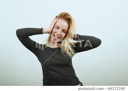 Silly Girl Having Fun, Holding Head With Hands, Sticking Out Her Tongue 68172390