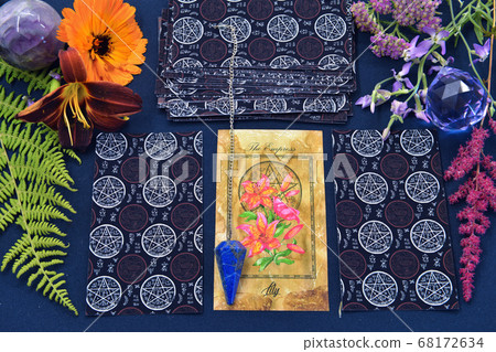 Mystic still life with tarot cards, crystal and flowers on witch table. Esoteric, gothic and occult background with magic objects and herbs. Halloween fortune telling concept. Mystic still life with tarot cards, crystal and flowers on witch table. Esoteric, gothic and occult background with magic objects and herbs. Halloween fortune telling concept. 68172634