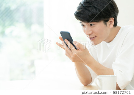 A man who communicates with a smartphone 68172701