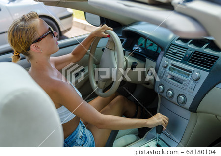 Woman driving on a parking lot Woman driving on a parking lot 68180104