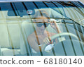 Woman driving a car 68180140