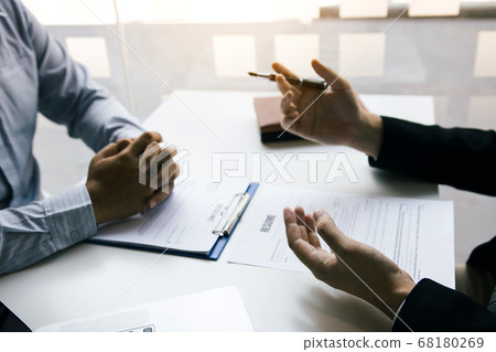Asian young adult sitting at desk across from Asian young adult sitting at desk across from 68180269