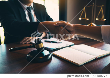 Lawyer is currently shaking hands with the client 68180273