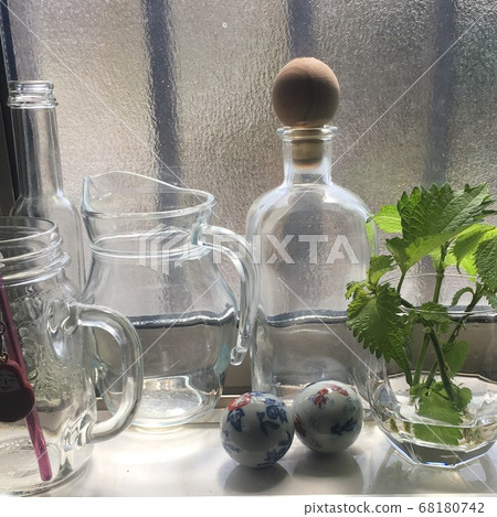 Glass bottles and perilla on the windowsill of the kitchen Glass bottles and perilla on the windowsill of the kitchen 68180742