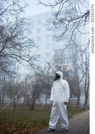 Man in gas mask and protective clothing outdoors. Man in gas mask and protective clothing outdoors. 68181474