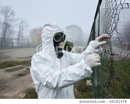 Man in protective clothing ripping wire fence. Man in protective clothing ripping wire fence. 68181476