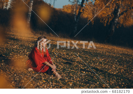 beautiful girl in a red dress in the autumn forest. nature walk. getting energy from the sun, trees. fairitale scene of a woman laying in the forest beautiful girl in a red dress in the autumn forest. nature walk. getting energy from the sun, trees. fairitale scene of a woman laying in the forest 68182170