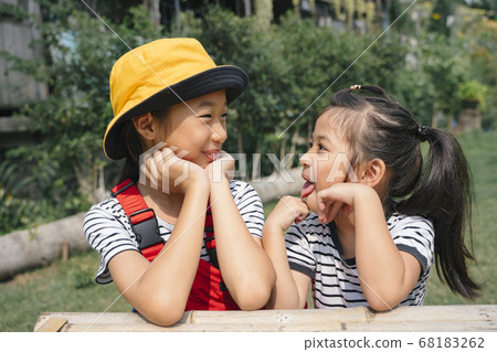 Close up playful asian girl sitting on the bench. 68183262