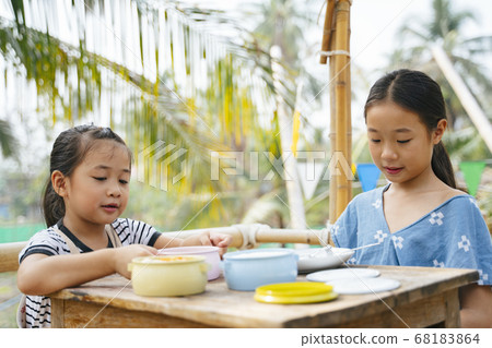 Two sisters eating together from Pinto. Two sisters eating together from Pinto. 68183864