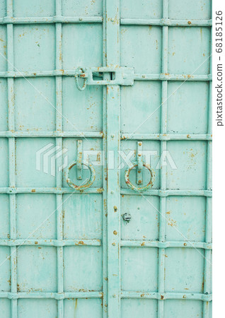 The metal gates are turquoise.With round rings handles. Metallic decorative forging. The metal gates are turquoise.With round rings handles. Metallic decorative forging. 68185126
