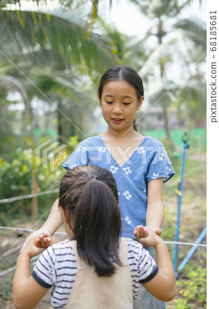 Two little asian girls helping each other in farm. Two little asian girls helping each other in farm. 68185681