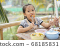 Asian girl eating deep fried shrimp with fork. 68185831