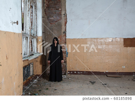 young goth woman stands in the room of an young goth woman stands in the room of an 68185898