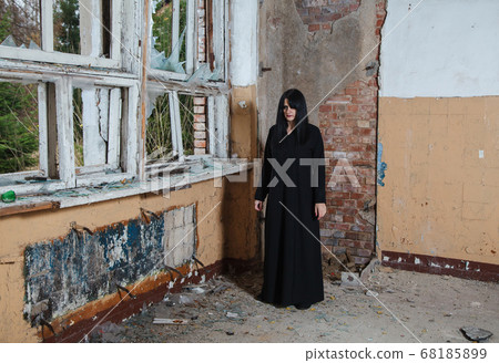 young goth woman stands in the room of an young goth woman stands in the room of an 68185899