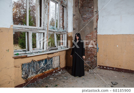 young goth woman stands in the room of an young goth woman stands in the room of an 68185900