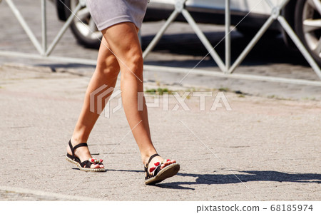 young woman walking on the sidewalk young woman walking on the sidewalk 68185974