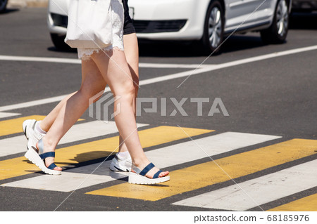 young women crossing the road at a pedestrian young women crossing the road at a pedestrian 68185976