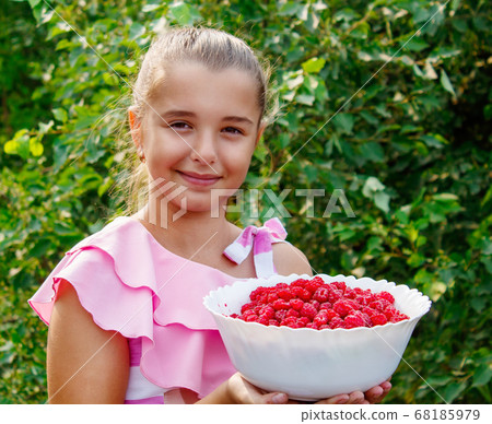 teen girl holding a dish of raspberries in the teen girl holding a dish of raspberries in the 68185979