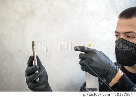 Man in the protective mask and gloves cleans a 68187594