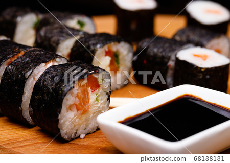 Sushi with salmon. Soy sauce, red caviar. Sushi on a black background. Sushi with salmon. Soy sauce, red caviar. Sushi on a black background. 68188181
