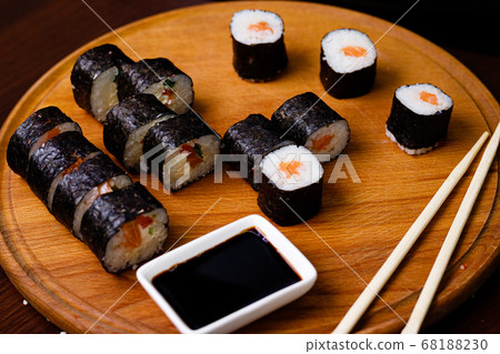 Sushi with salmon. Soy sauce, red caviar. Sushi on a black background. Sushi with salmon. Soy sauce, red caviar. Sushi on a black background. 68188230