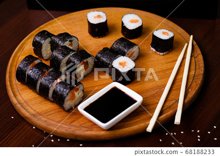 Sushi with salmon. Soy sauce, red caviar. Sushi on a black background. 68188233