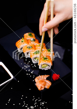 Sushi with salmon. Soy sauce, red caviar. Sushi on a black background. Sushi with salmon. Soy sauce, red caviar. Sushi on a black background. 68188236