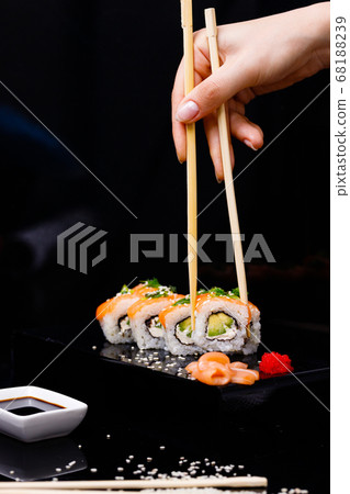 Sushi with salmon. Soy sauce, red caviar. Sushi on a black background. Sushi with salmon. Soy sauce, red caviar. Sushi on a black background. 68188239