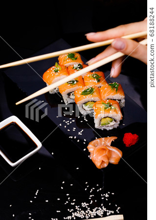 Sushi with salmon. Soy sauce, red caviar. Sushi on a black background. Sushi with salmon. Soy sauce, red caviar. Sushi on a black background. 68188244