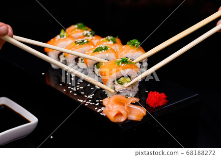 Sushi with salmon. Soy sauce, red caviar. Sushi on a black background. Sushi with salmon. Soy sauce, red caviar. Sushi on a black background. 68188272