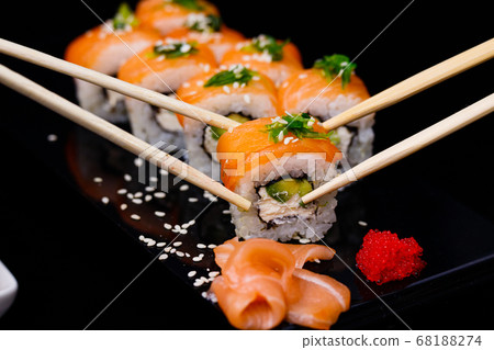 Sushi with salmon. Soy sauce, red caviar. Sushi on a black background. Sushi with salmon. Soy sauce, red caviar. Sushi on a black background. 68188274