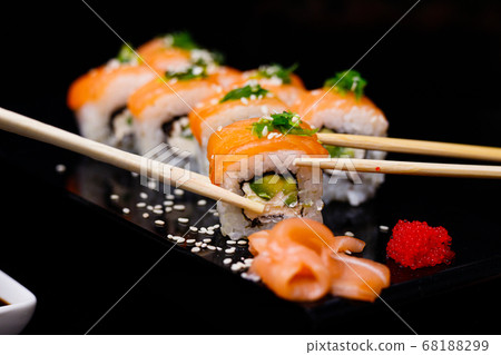 Sushi with salmon. Soy sauce, red caviar. Sushi on a black background. Sushi with salmon. Soy sauce, red caviar. Sushi on a black background. 68188299